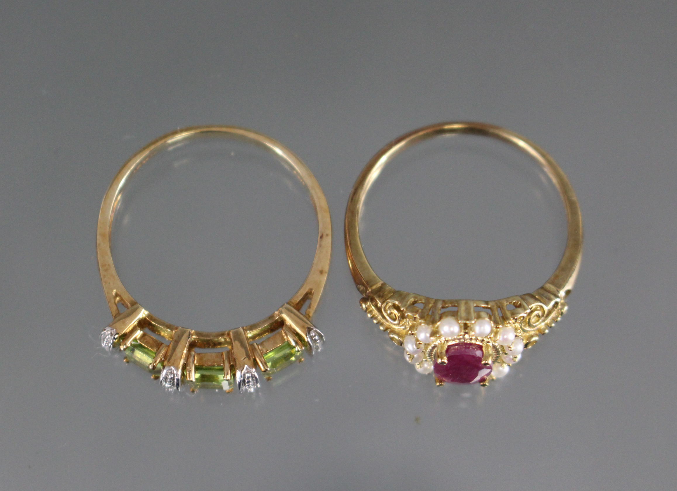 An un-marked yellow metal ring set oval ruby within a border of seed pearls & with pierced scroll - Image 2 of 2