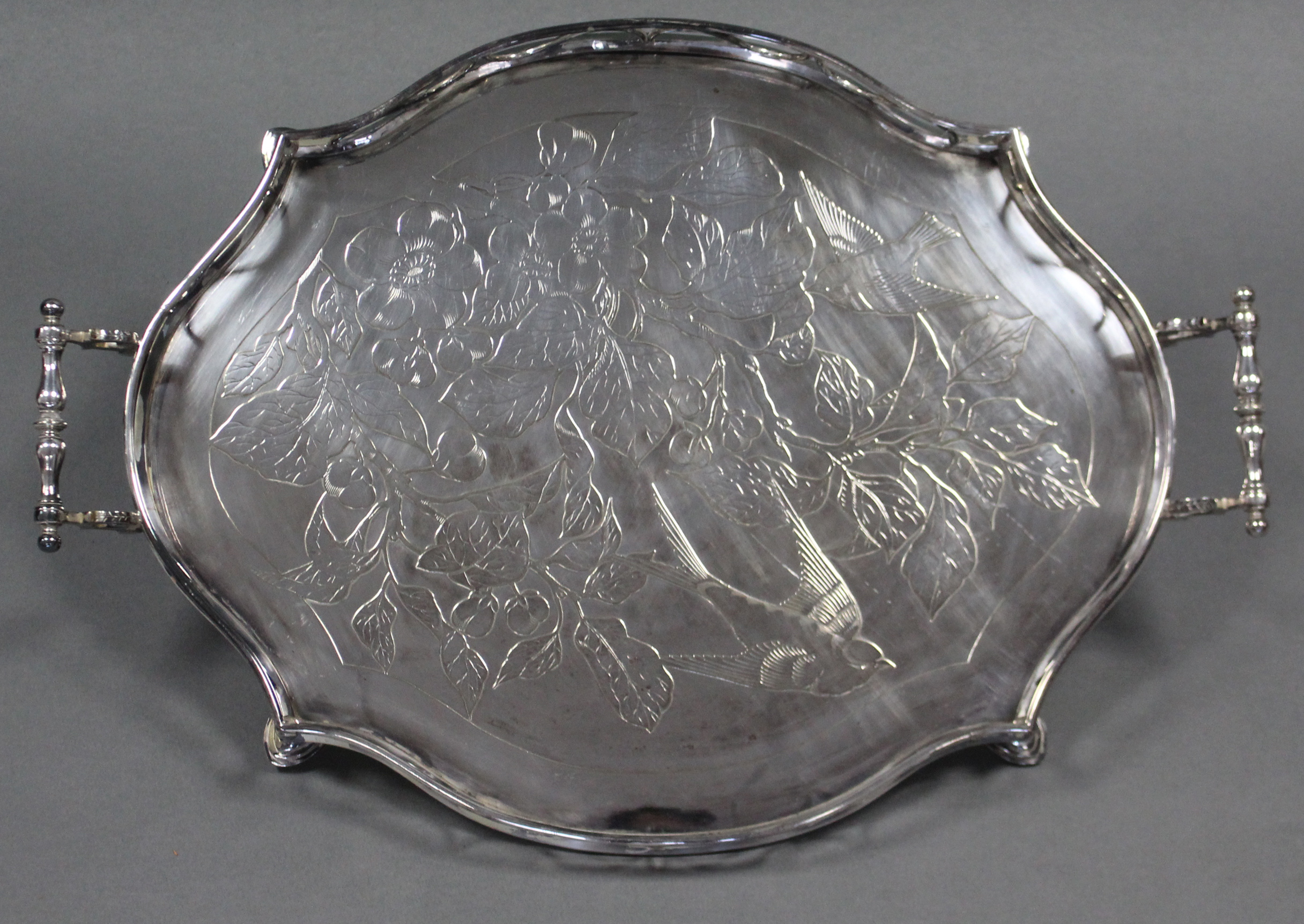 An Edwardian silver-plated shaped oval two-handled tray with embossed decoration of a bird amongst - Image 2 of 3