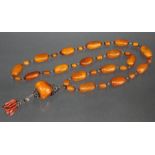 AN ORIENTAL BUTTERSCOTCH AMBER NECKLACE of alternating large & small oval beads, the large