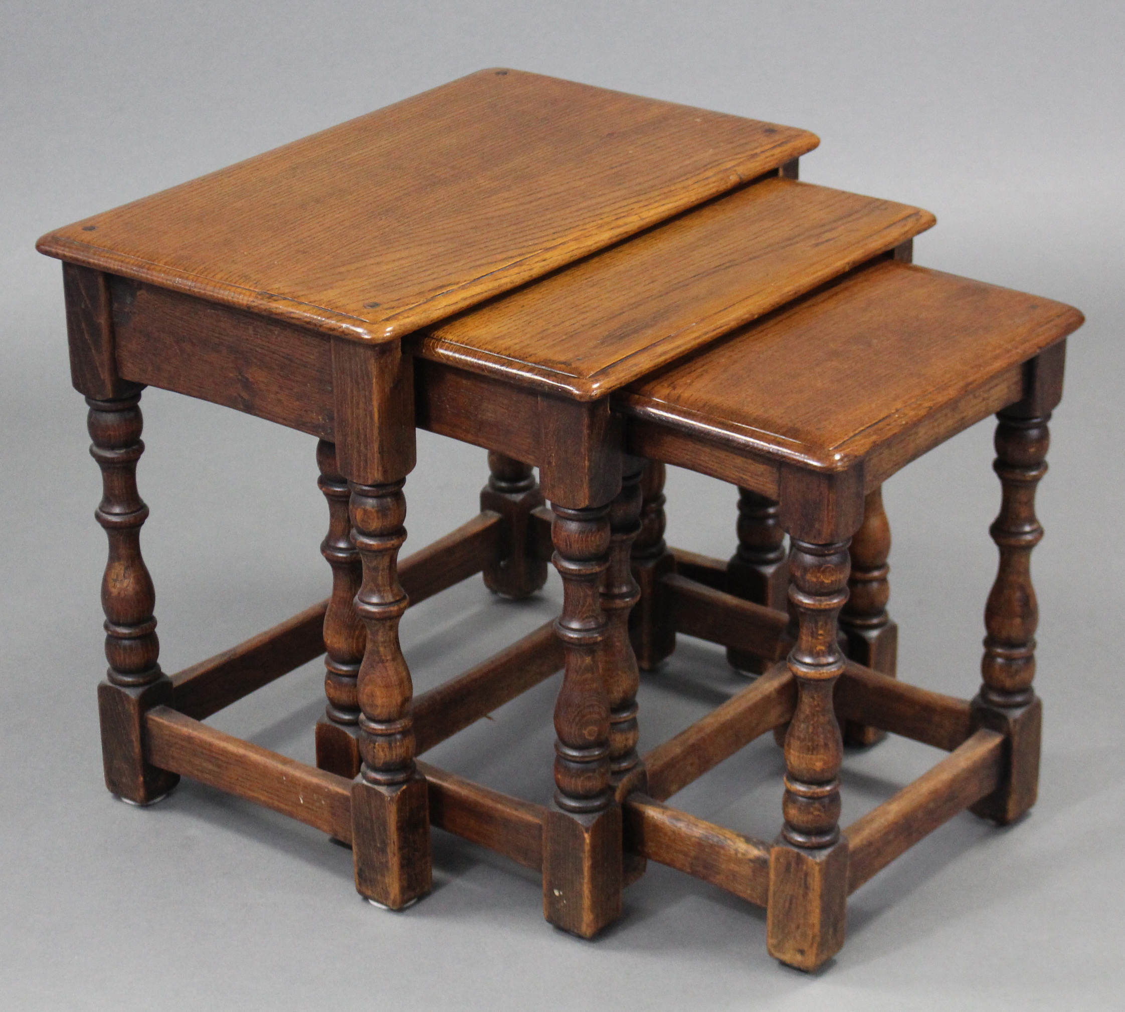 A nest of three 17th century style oak rectangular occasional tables on turned legs with plain