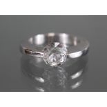 *LOT WITHDRAWN* A white metal ring marked “750”, set single round-cut white sapphire of approx.