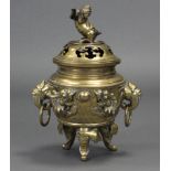 A Chinese cast brass tripod censer with raised decoration of dragons chasing the pearl & with