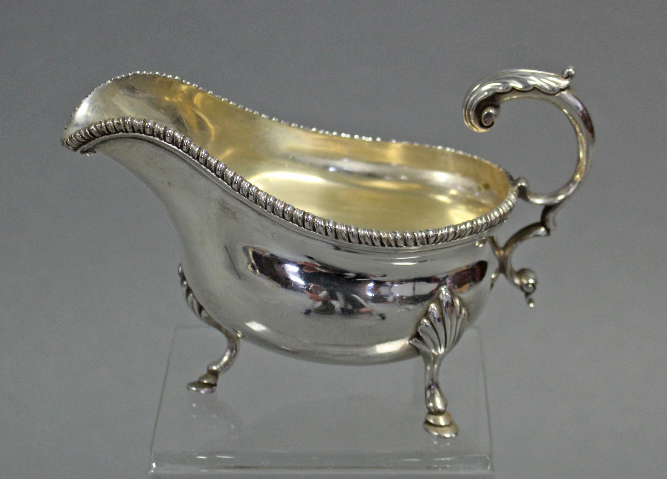 An Edwardian silver oval sauce boat with gadrooned rim, open acanthus scroll handle, & on three - Image 2 of 3