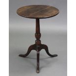 A late 18th century oak tripod table with circular top on vase-turned centre column & slender