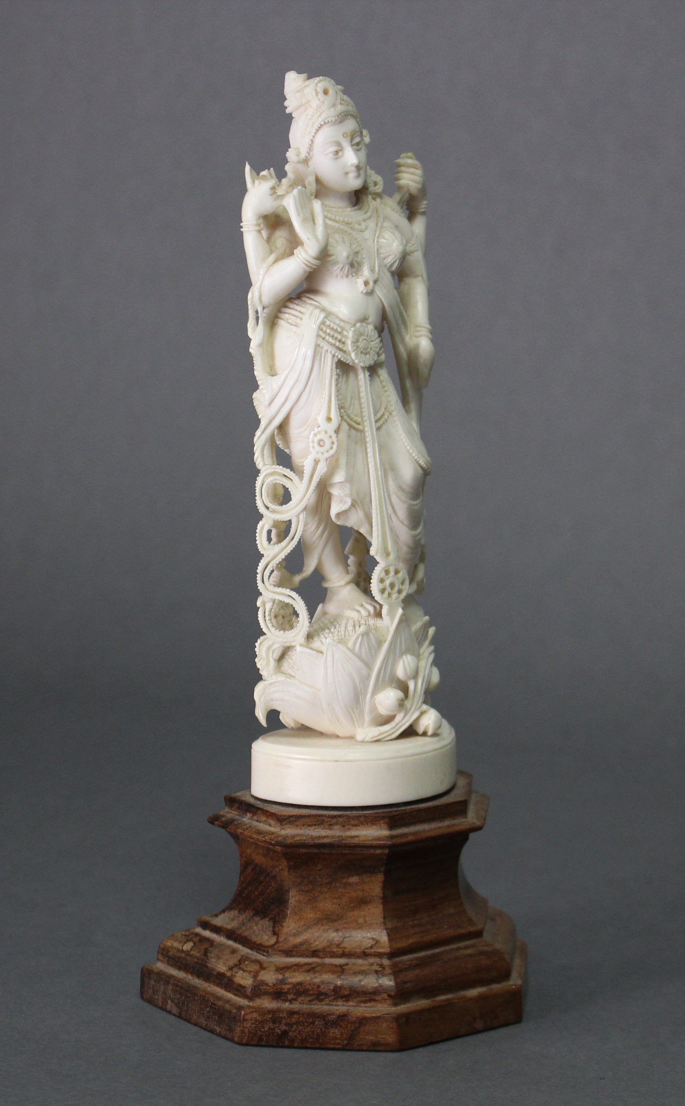 A 19th century ivory model of the goddess Laxmi, on wooden plinth base; 9“ high.