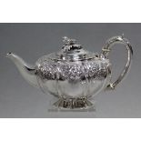 A George IV silver melon-shaped teapot, the shoulders embossed with panels of fruit & flowers, acorn