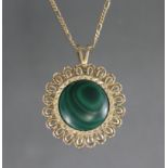 A malachite circular pendant in 9ct. gold wide loop-design border, with 9ct. gold fine-link chain