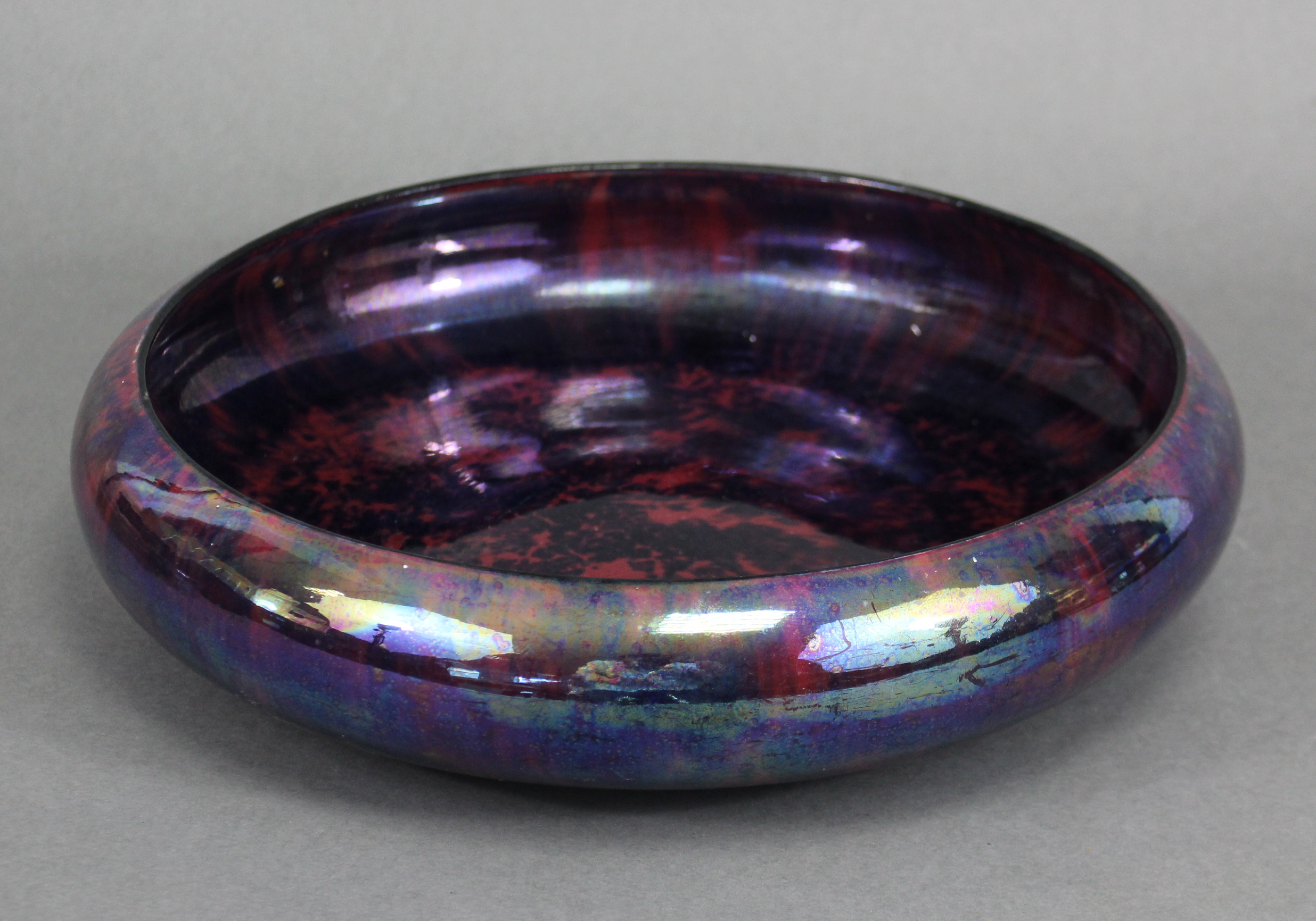 A 1930’s Burslem lusterware shallow bowl of mottled deep purple ground, 11½” diam.