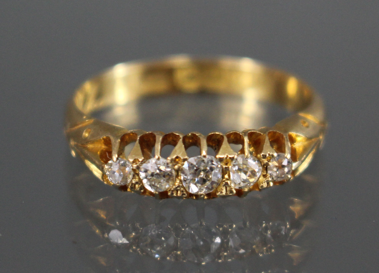 A late Victorian 18ct. gold ring set five small graduated diamonds, Birmingham hallmarks for 1899;