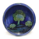 A WILLIAM MOORCROFT “MOONLIT BLUE” CIRCULAR SHALLOW BOWL on round pedestal foot, painted signature &