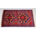 A Baluchi rug of crimson & deep blue ground, with pair of central lozenges in geometric border; 4’9”