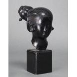 A bronze model of a Vietnamese female head, on wooden block base; 7.5“ high.