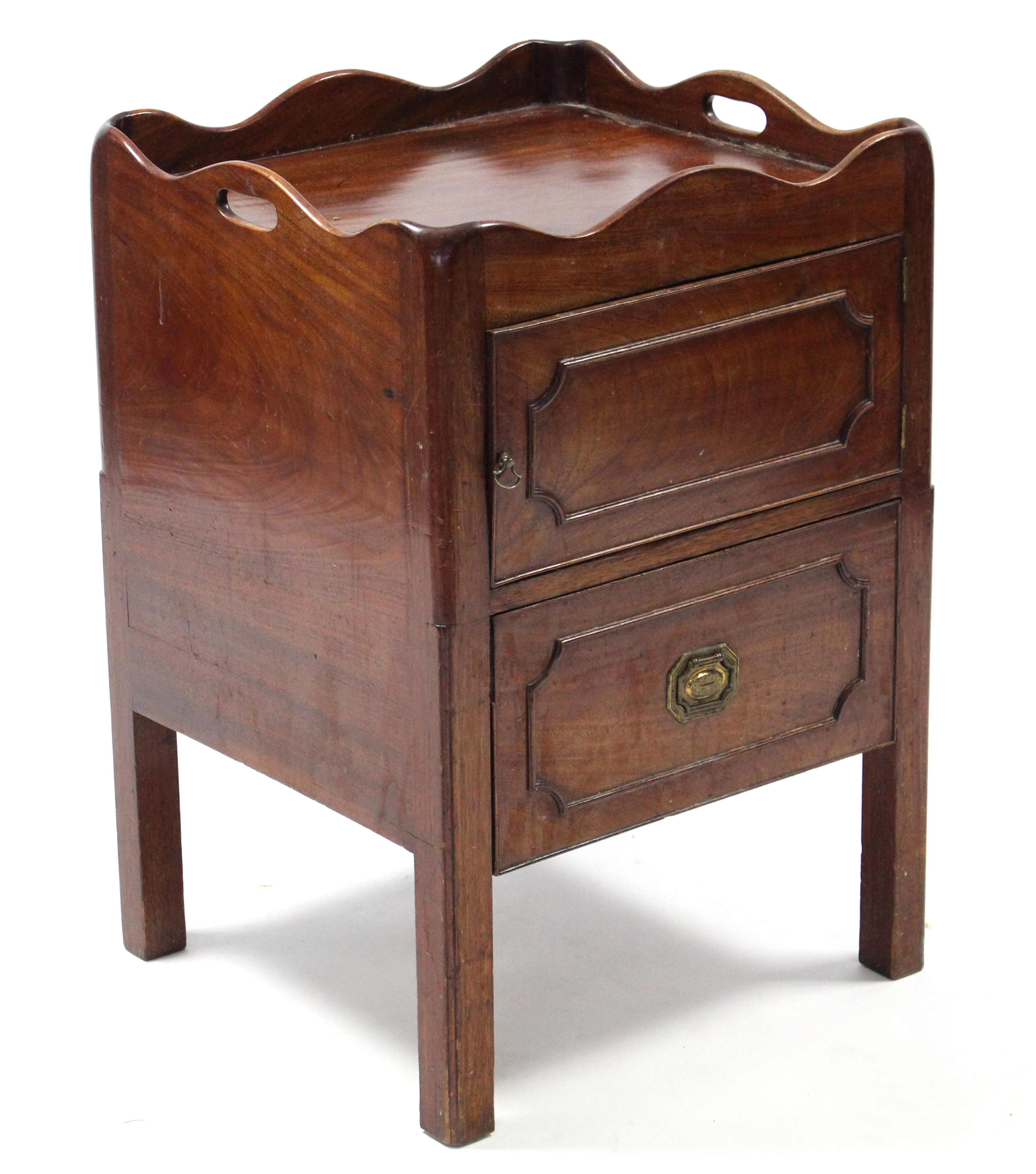A late 18th century mahogany tray-top bedside commode enclosed by panel door; 20½” wide.