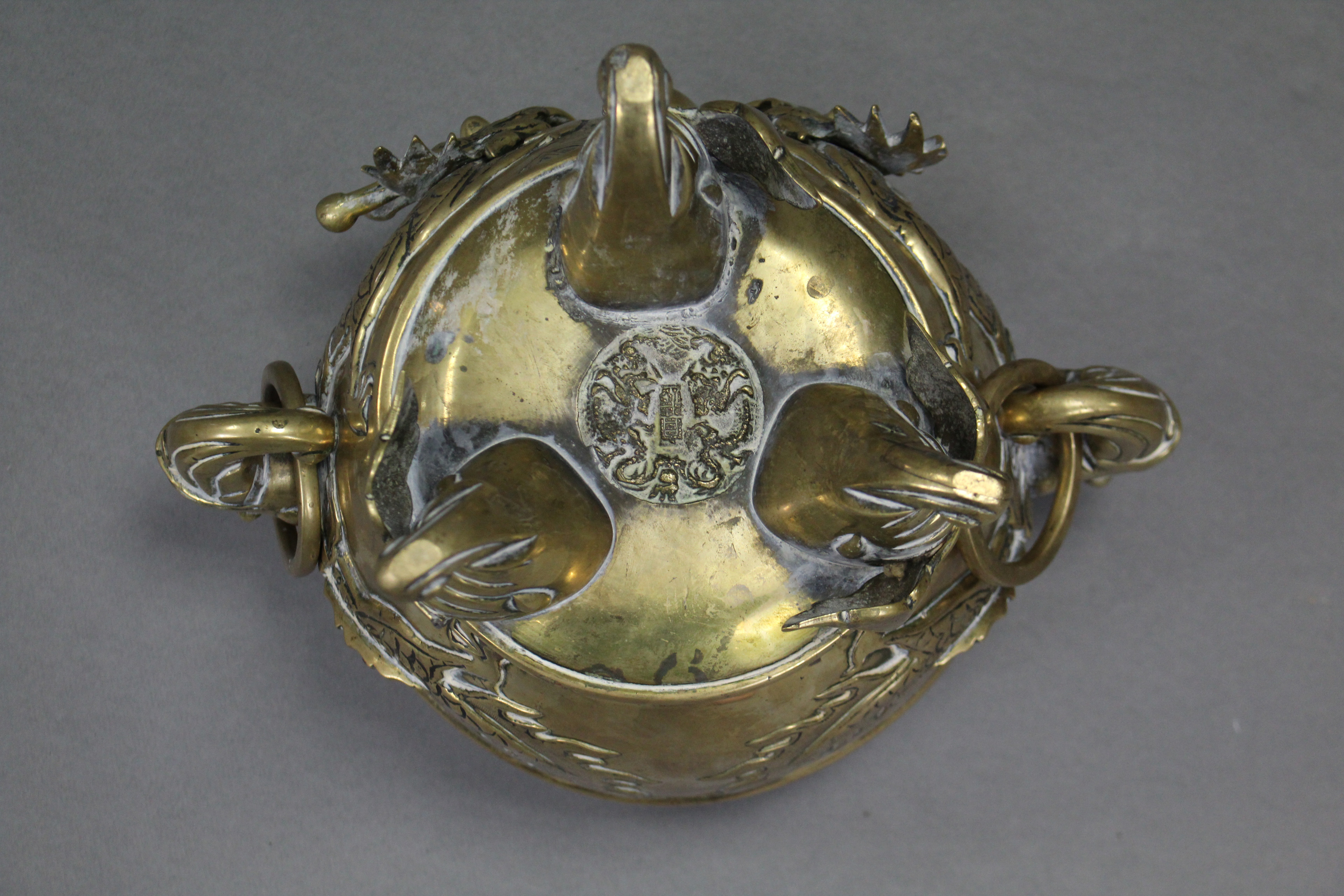 A Chinese cast brass tripod censer with raised decoration of dragons chasing the pearl & with - Image 4 of 4