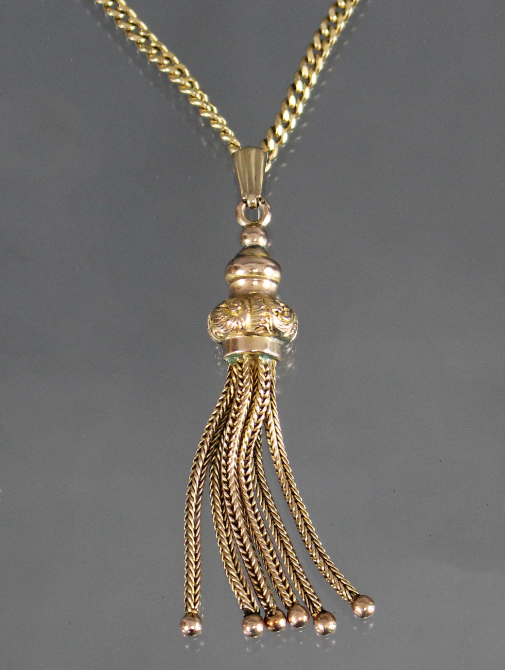 A yellow metal chain necklace of flattened curb links, marked “750”, 24” long (13.4gm); with gilt-