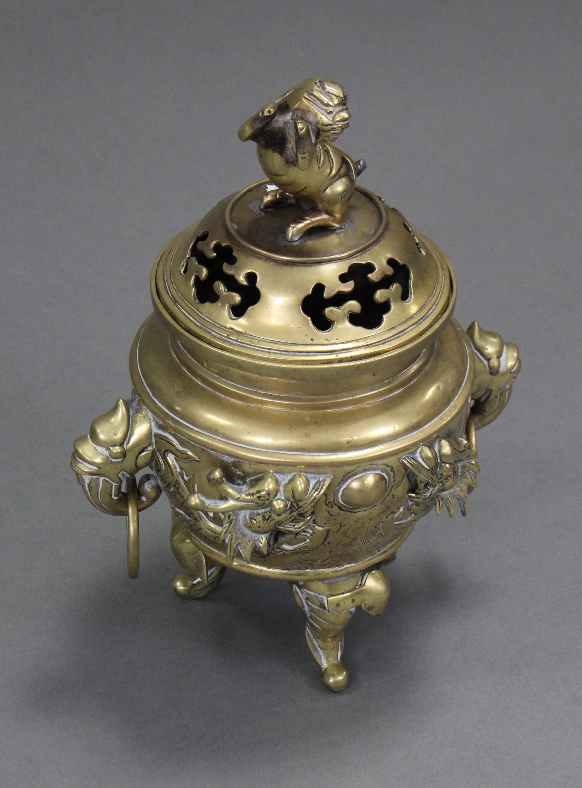 A Chinese cast brass tripod censer with raised decoration of dragons chasing the pearl & with - Image 2 of 4