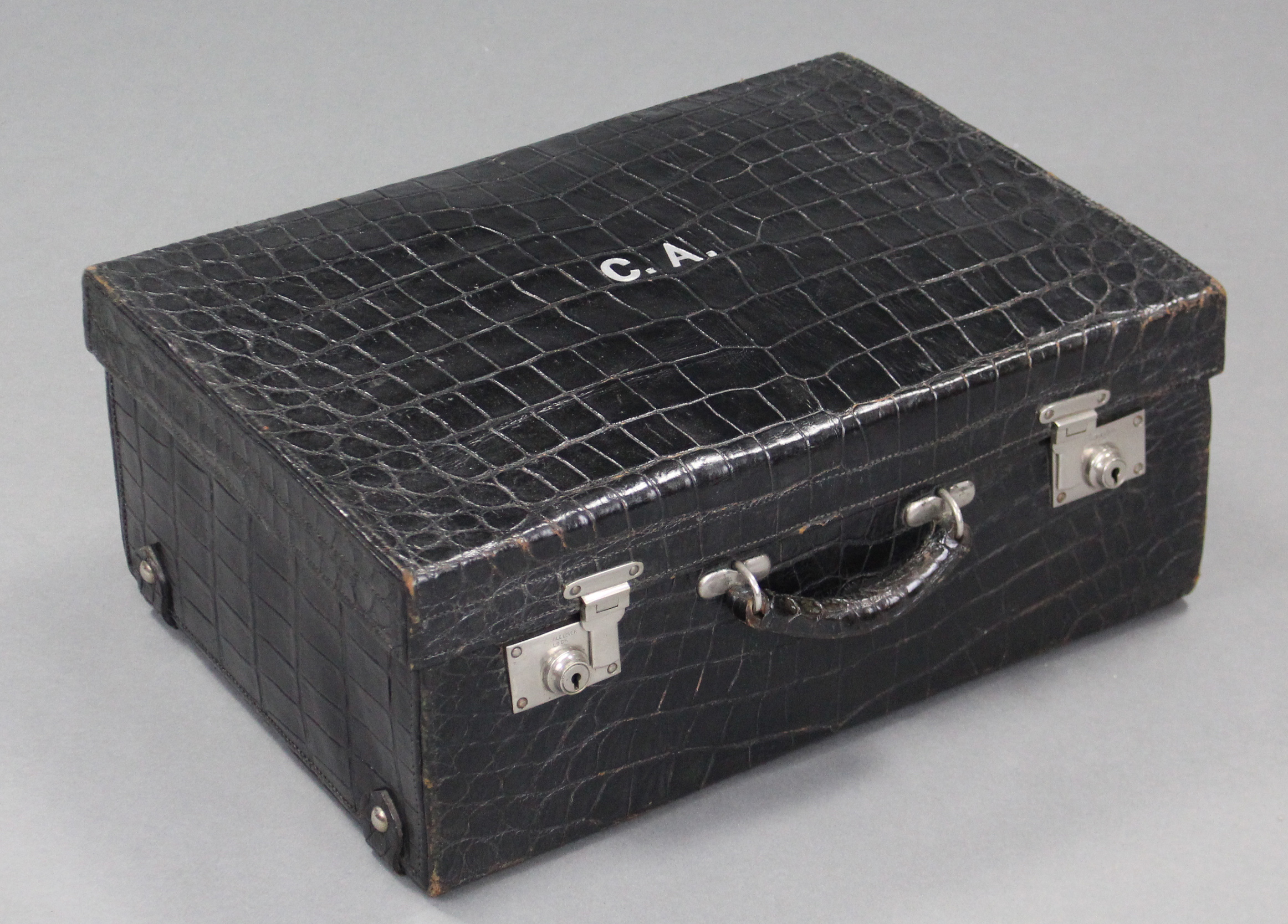 A black crocodile skin suitcase with green moiré silk lining, & silvered twin locks.