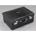 A black crocodile skin suitcase with green moiré silk lining, & silvered twin locks.