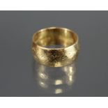 An 18ct. gold wedding band with engraved flower-head design; Birmingham hallmarks for 1991. (Size: