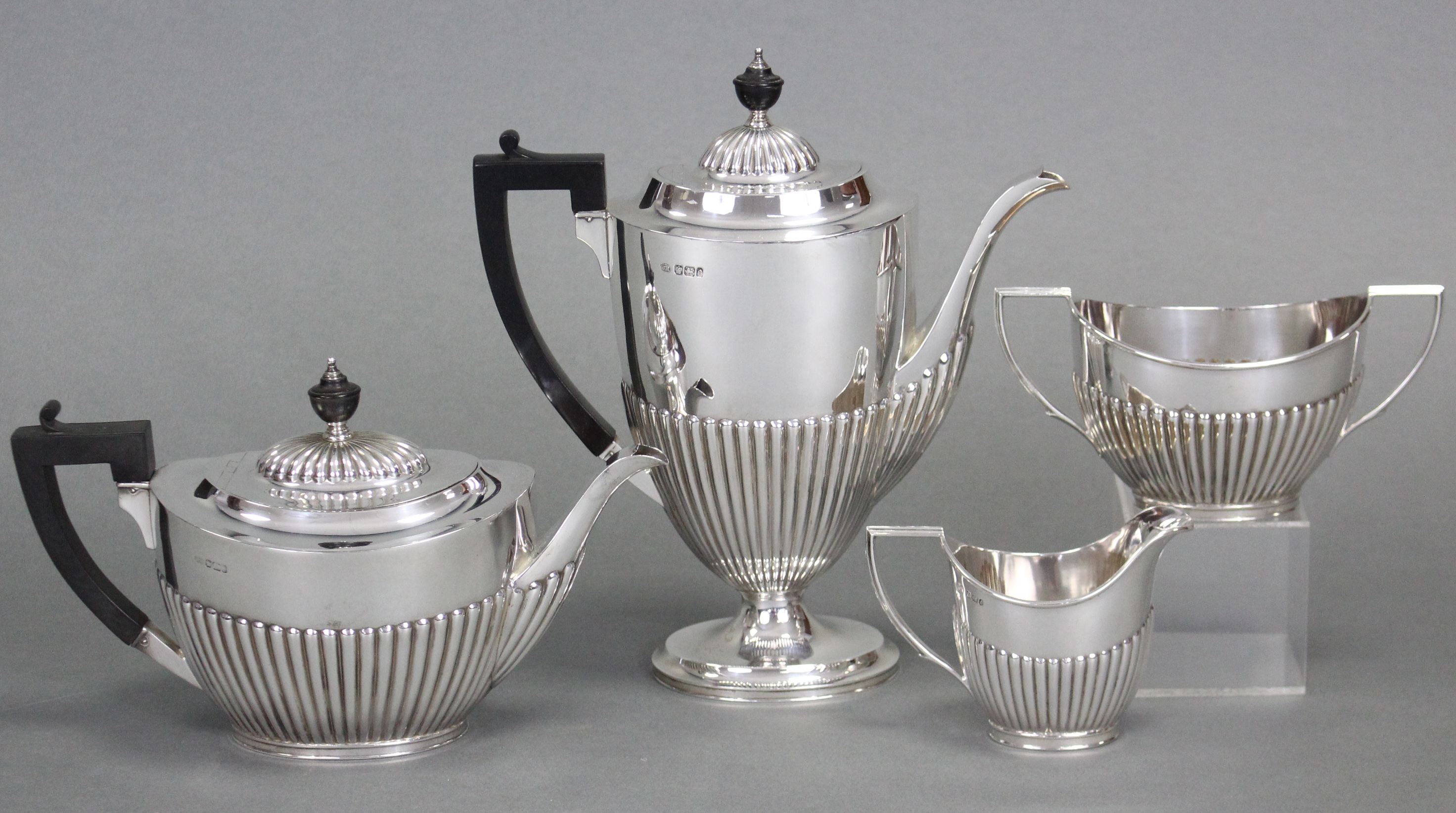 A late Victorian silver four-piece tea & coffee service of oval semi-fluted design, the coffee pot