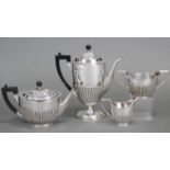 A late Victorian silver four-piece tea & coffee service of oval semi-fluted design, the coffee pot