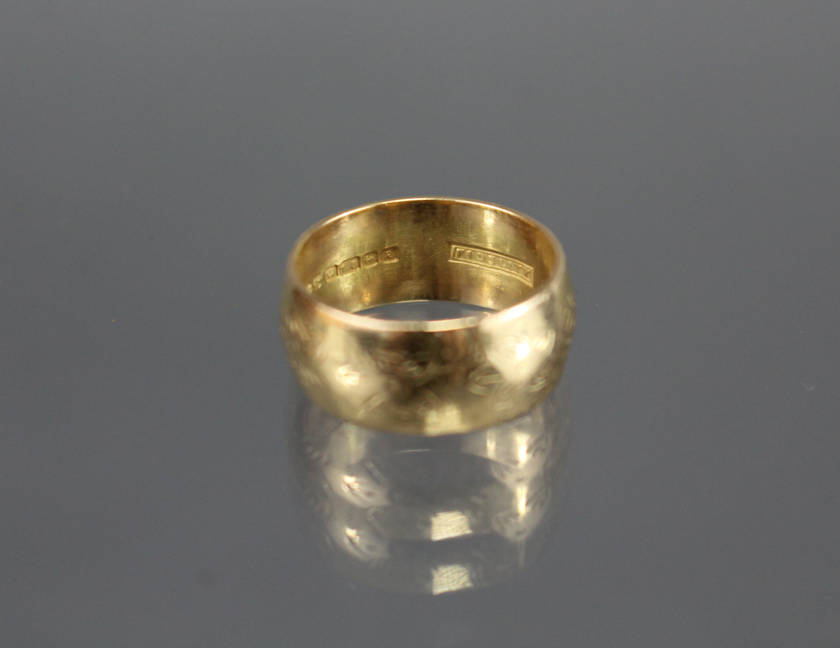 An 18ct. gold wedding band with engraved flower-head design; Birmingham hallmarks for 1991. (Size: - Image 2 of 2
