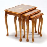 A reproduction inlaid nest of three rectangular occasional tables inset glass tops.
