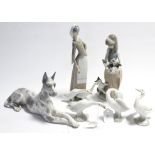 A Lladro Great Dane ornament, 6½” high x 12” long; two standing Lladro figures, 9¾” & 11” high; &