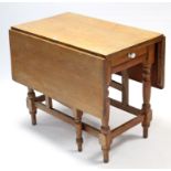 A pine drop-leaf kitchen table fitted end drawer, & on baluster-turned legs & turned feet with plain