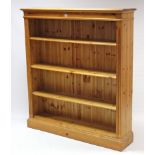 A pine standing open bookcase with three adjustable shelves, & on plinth base, 49½” wide x 54½”