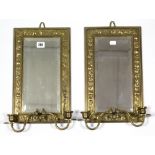 A pair of Edwardian brass embossed frame girandoles, each inset bevelled plate & with twin sconces