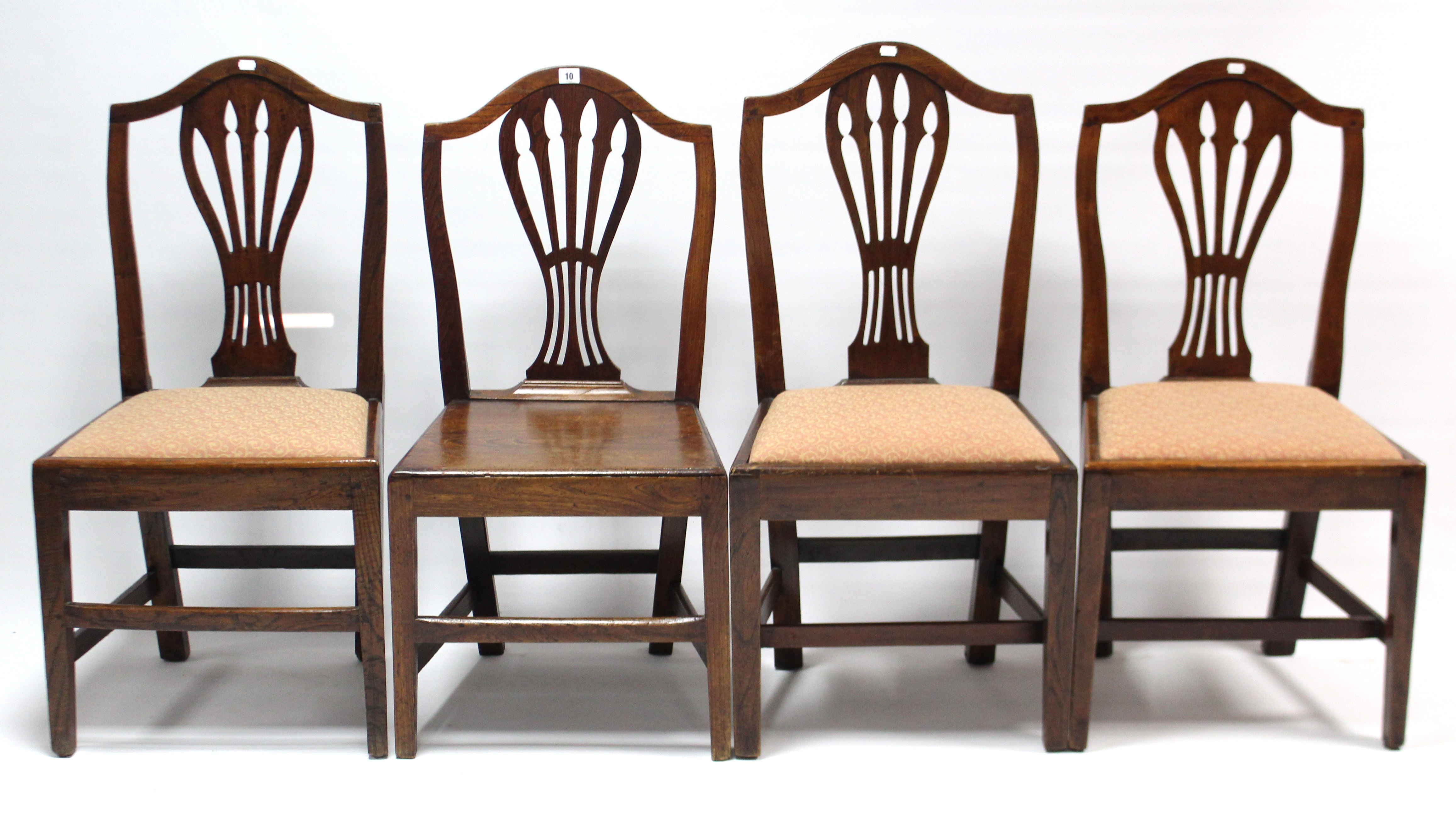 Four Hepplewhite-style mahogany dining chairs (one with hard seat), each on square tapered legs with