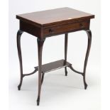An Edwardian mahogany card table inset green baize to the rectangular fold-over top, fitted frieze