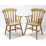 A pair of beech lath-back elbow chairs, with hard seats & on turned legs with spindle stretchers.