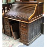 A late 19th/early 20th century oak roll-top pedestal desk with fitted interior enclosed by tambour