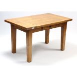 A light oak dining table with rectangular top, fitted centre frieze drawer, & on four square tapered