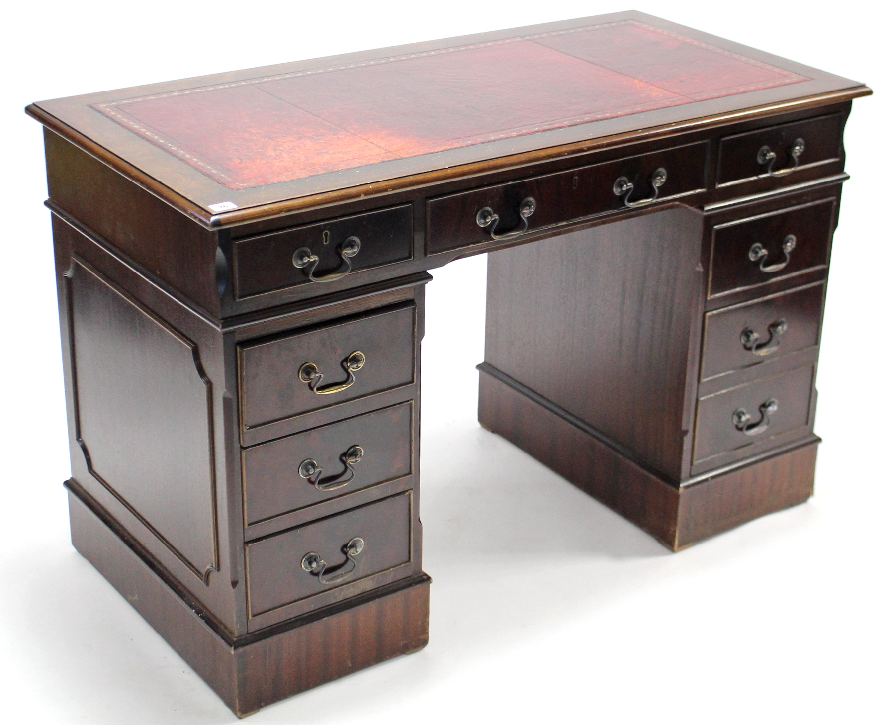 A reproduction mahogany pedestal desk-inset gilt tooled crimson leather cloth, fitted with an