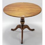 A mahogany circular tripod table with circular top, & on fluted & vase-turned centre column &