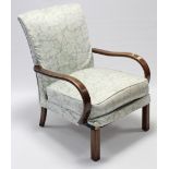 An Arts & Crafts beech frame upholstered armchair with open arms, & on short square legs.