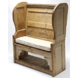 A pine settle with panelled back & shaped sides, hard seat above an open recess, 42¼” wide x 52”