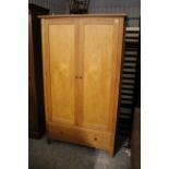 A light oak finish wardrobe enclosed by pair of panel doors above a deep long drawer, 43¼” wide x