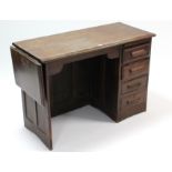 An oak typist’s desk with drop-leaf to the left-hand side, & fitted four long drawers to the right-