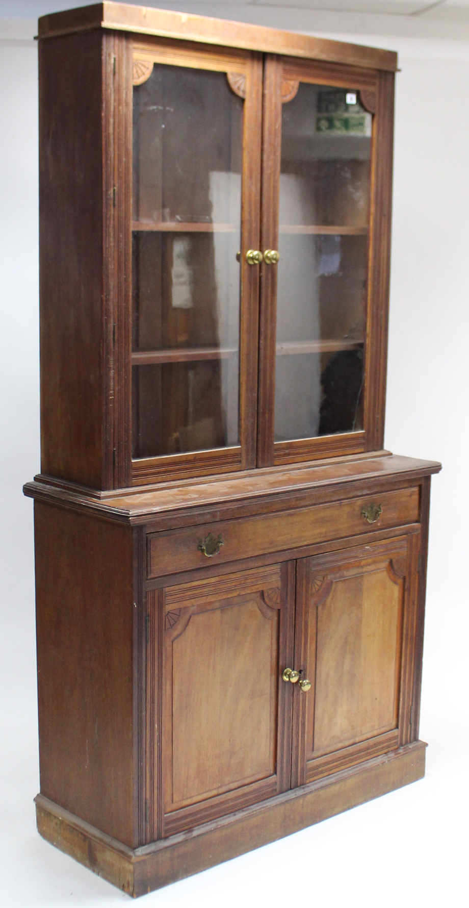 A late Victorian mahogany tall bookcase, the upper part with two adjustable shelves enclosed by pair