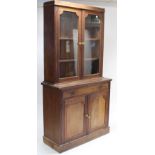 A late Victorian mahogany tall bookcase, the upper part with two adjustable shelves enclosed by pair