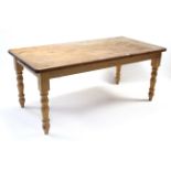 A pine kitchen table with rounded corners to the rectangular top, & on four turned tapered legs, 72”