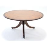 A reproduction mahogany large coffee table, inset tooled brown leather to the circular top, & on