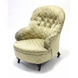 A late Victorian buttoned-back easy chair, upholstered pale green damask, & on short turned legs