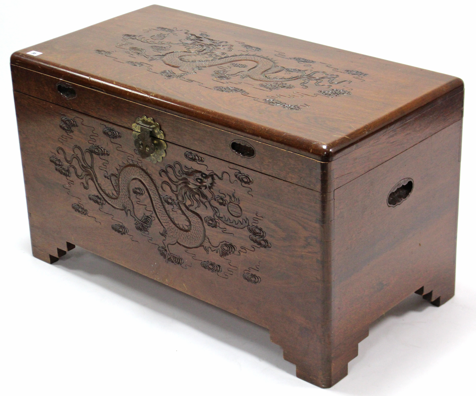 A Chinese teak camphor wood chest with carved dragon design to the hinged lift-lid & front, & on