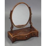 A George III figured mahogany oval swing toilet glass on scroll supports & inlaid serpentine-front