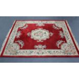 A Chinese carpet of crimson ground with central medallion & wide floral borders, 122” x 95”.